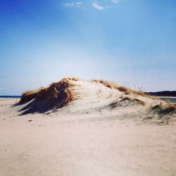 Scenic view of beach against blue sky