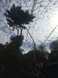 Low angle view of power lines against cloudy sky