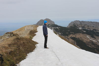 Hiker standing on snow at giewont mountain