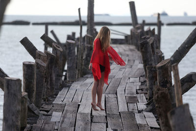 Rear view of woman walking on railing