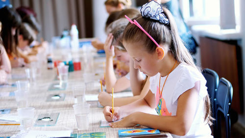 Drawing lesson, in the classroom children draw with colors, master the technique of drawing on glass