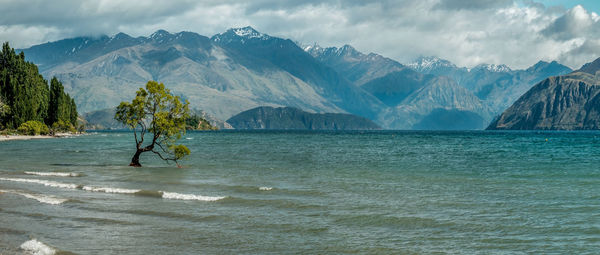 Scenic view of sea and mountains against sky