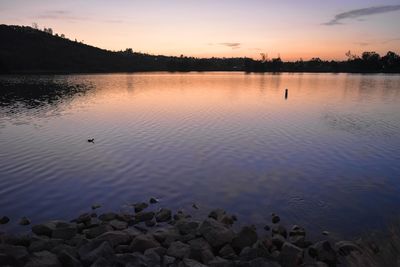 Scenic view of lake against sky at sunset