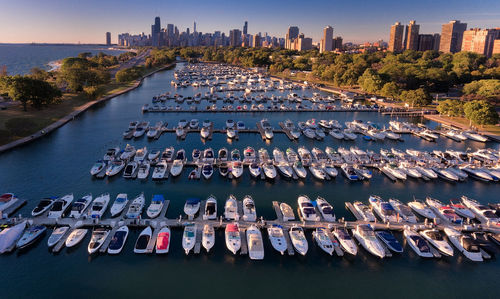 High angle view of boats moored at harbor in city against sky