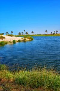 Scenic view of lake against clear blue sky