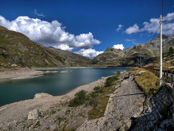 Scenic view of lake by mountains against sky