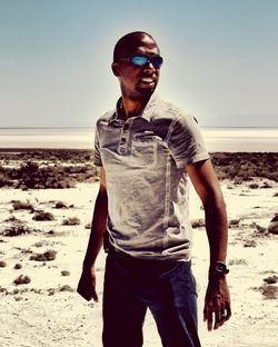 Portrait of young man standing on beach