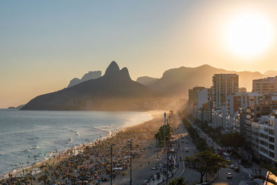 Aerial view of buildings by sea against clear sky