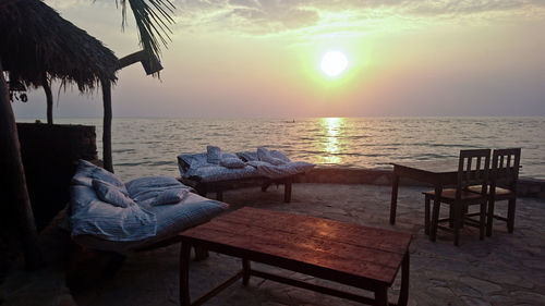 Low section of person on table at beach during sunset