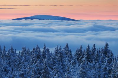 Scenic view of snow covered mountains against sky at sunset