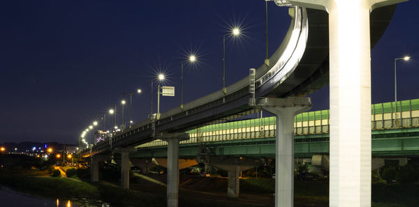 Illuminated bridge against sky at night