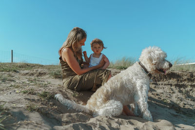 Dog and woman on land against sky