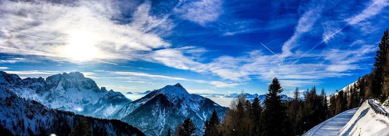 Scenic view of snow covered mountains against blue sky