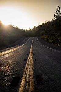 Empty road against sky during sunset