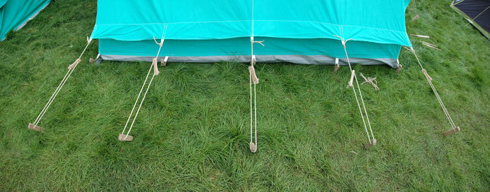 High angle view of ropes attached to tent on grassy field