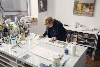 High angle view of senior woman drawing on table