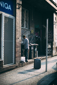 Full length of man standing against door of building