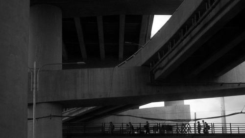 Low angle view of bridge in city against sky