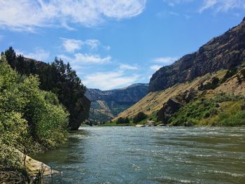 Scenic view of river and mountains against sky