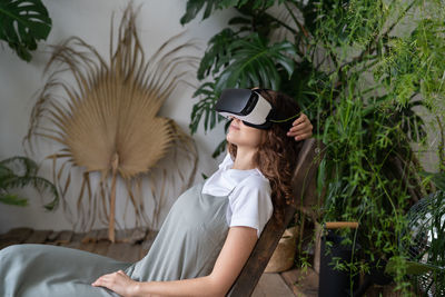 Amazed young woman using vr in home garden, resting in relaxing virtual environment. cyberspace.