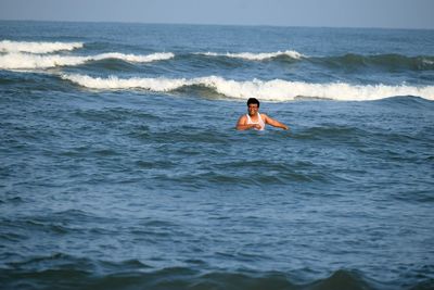 Rear view of woman swimming in sea