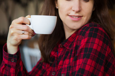 Midsection of woman holding coffee cup outdoors