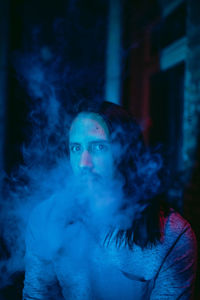 Portrait of man smoking in darkroom 