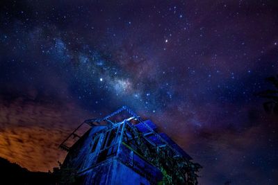 Low angle view of building against star field at night