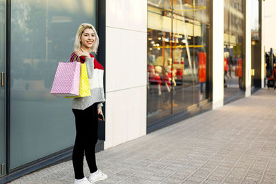 Portrait of young woman standing in city