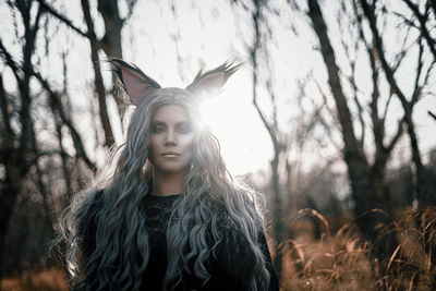 Young woman standing against tree during autumn