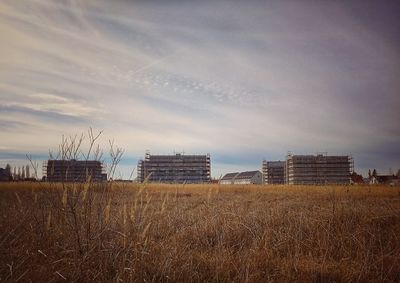 Buildings on field against sky
