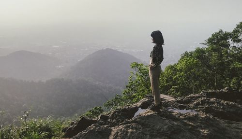 Man standing on rock against mountain