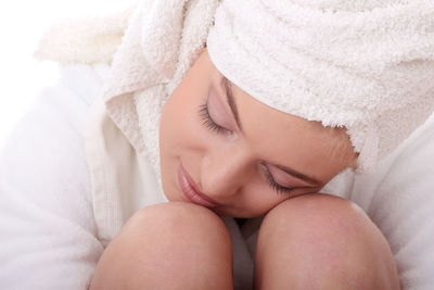 Woman in towel and bathrobe against white background