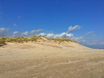 Scenic view of desert against blue sky