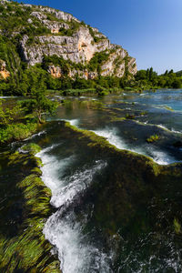 Scenic view of waterfall against sky