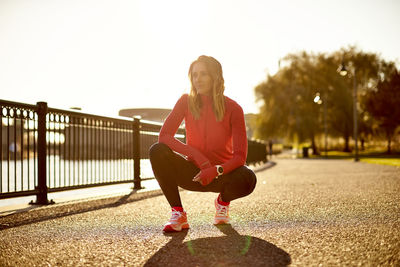 A backlit portrait of a female runner at rest.