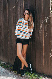 Full length of woman standing by fence