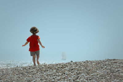 Rear view of boy running on beach