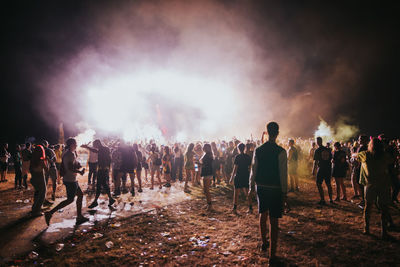 Rear view of people standing against blurred background