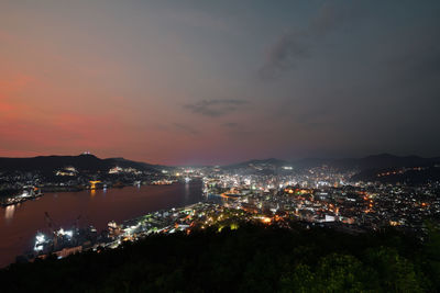 High angle view of illuminated buildings against sky at night