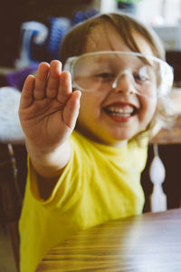 Portrait of cheerful boy gesturing while sitting at table