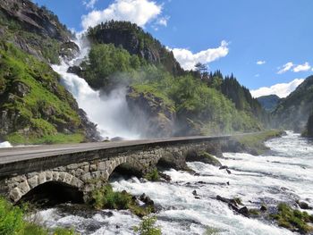 Scenic view of waterfall against sky