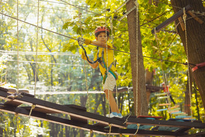 Low angle view of young woman standing against trees