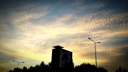 Silhouette of building against cloudy sky