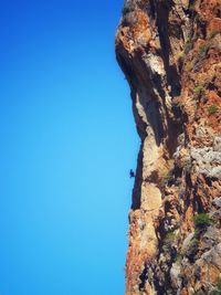 Low angle view of rock formation against clear blue sky