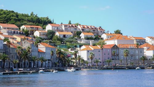 Houses by sea against sky in town