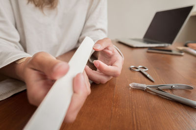 Midsection of woman using smart phone on table