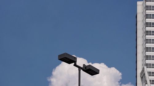 Low angle view of telephone pole against blue sky