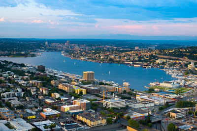 High angle view of buildings by river against sky