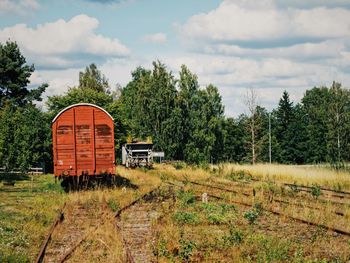 Abandoned train on field against sky